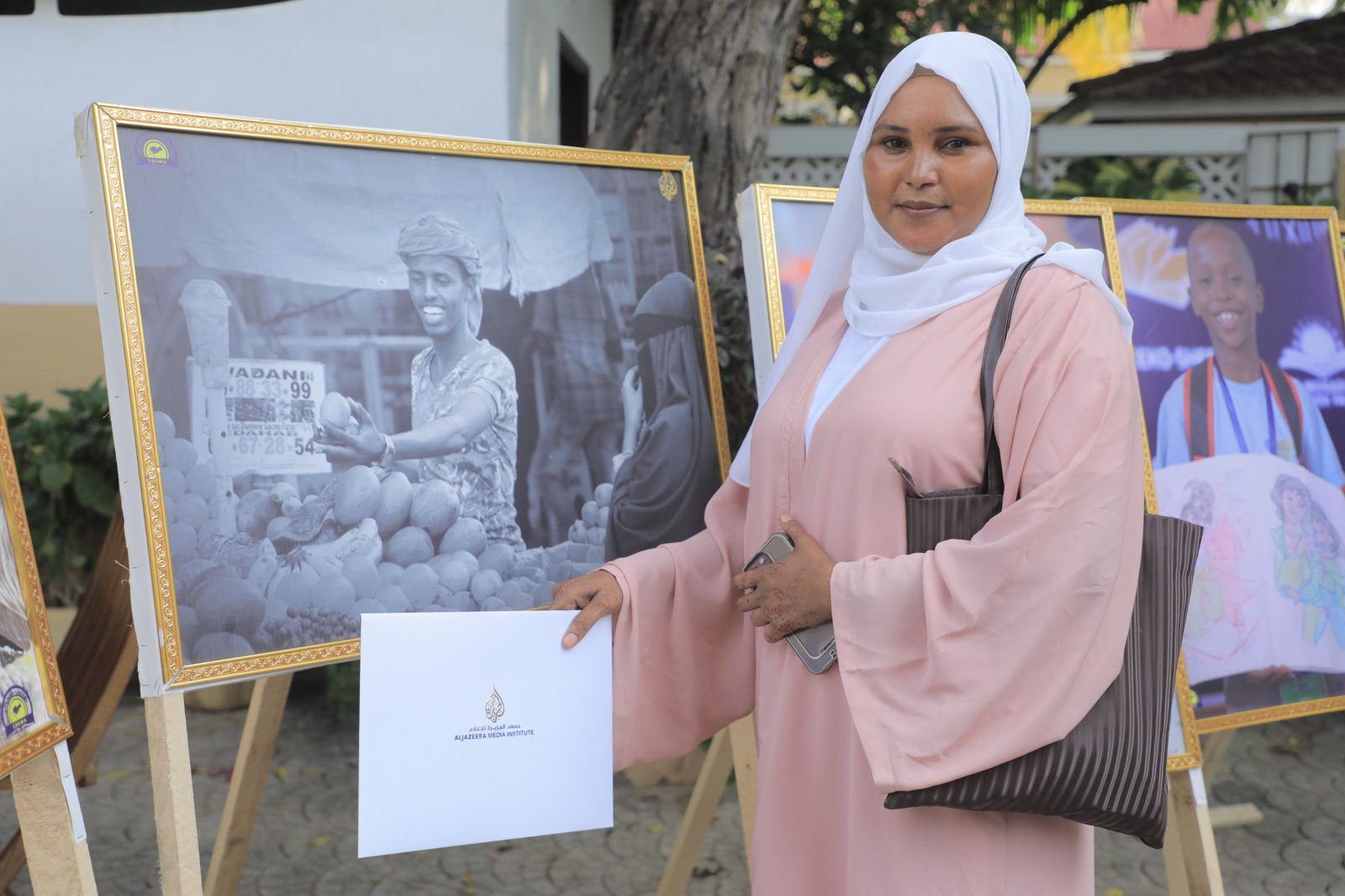 Khadro Ahmed Biid holding her Al Jazeera Media Institute certificate at a SODMA photo exhibition